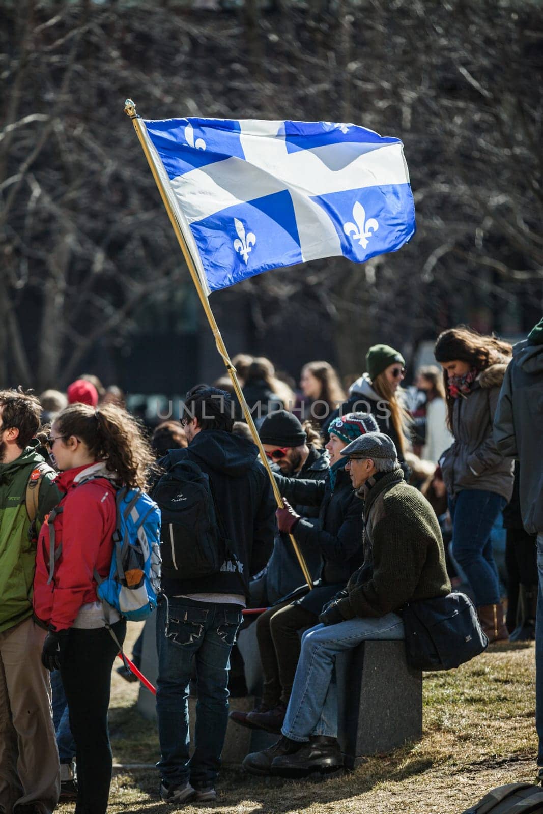 MONTREAL, CANADA, APRIL 02 2015. Riot in the Montreal Streets to counter the Economic Austerity Measures. Someone Holding Quebec Province Flag in the crowd