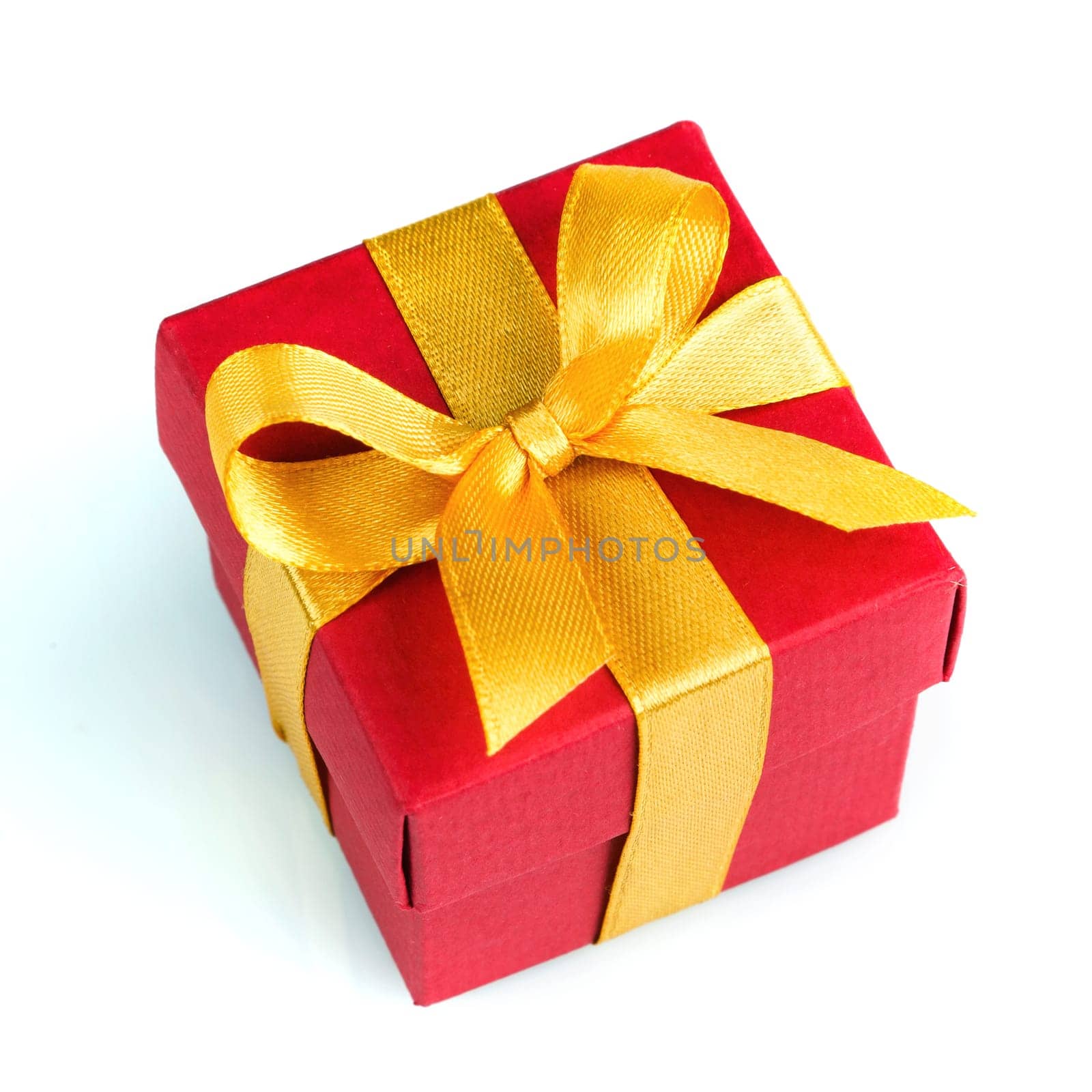 red gift box with golden ribbon and bow isolated on white top view