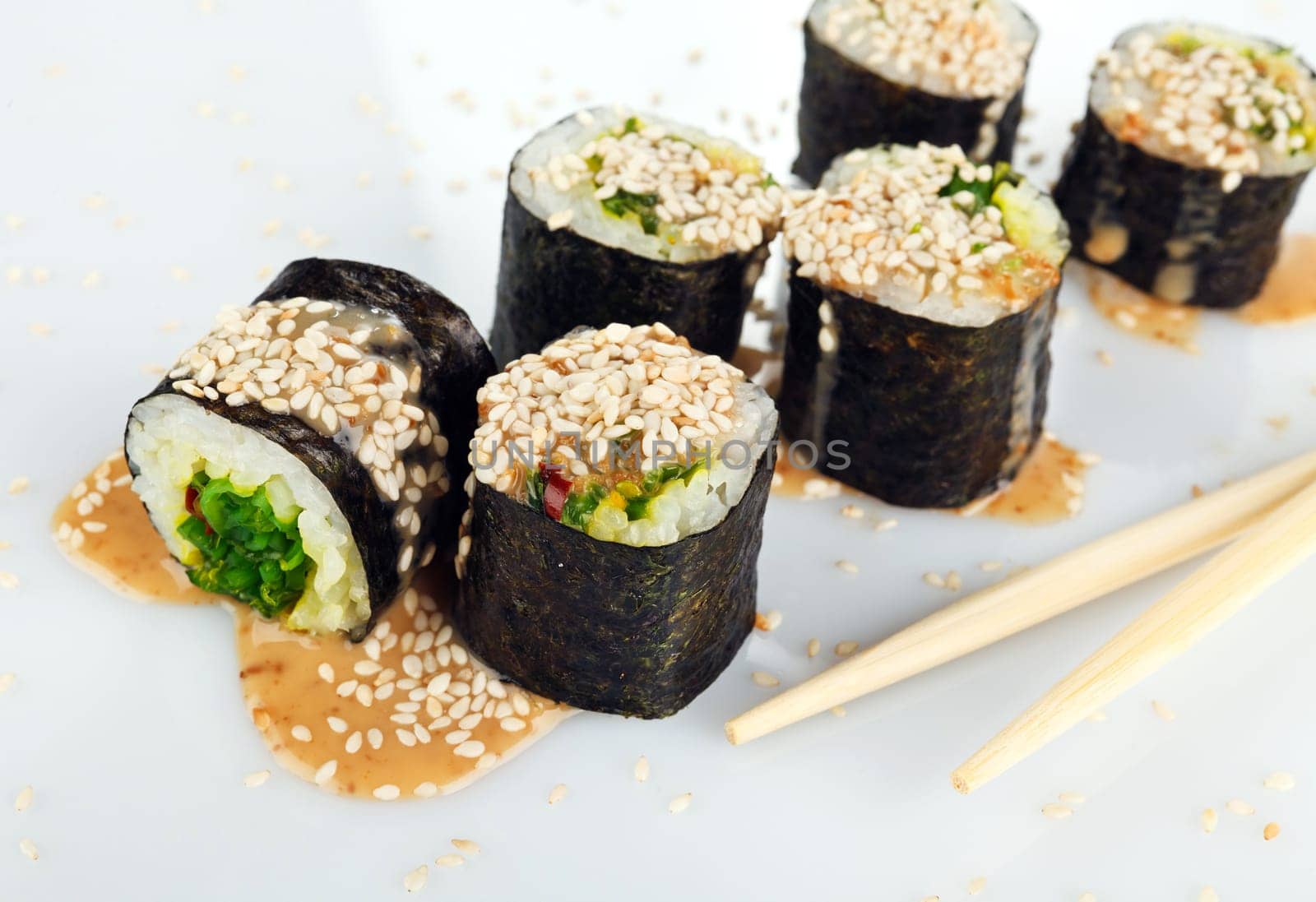 Traditional japanese sushi with sauce and sesame seeds isolated on white background