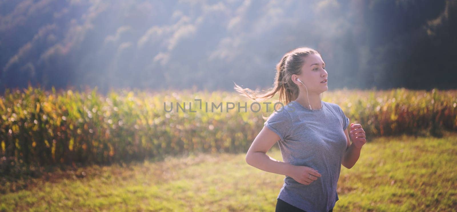 young woman enjoying in a healthy lifestyle while jogging along a country road, exercise and fitness concept