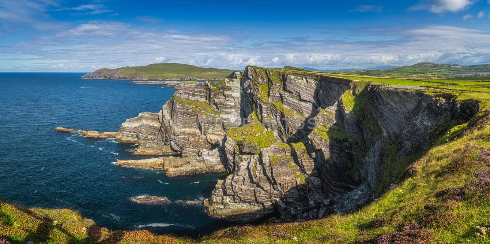 Large panorama with majestic tall Kerry Cliffs and turquoise coloured Atlantic Ocean on a sunny summer day, Portmagee, Ring of Kerry, Ireland