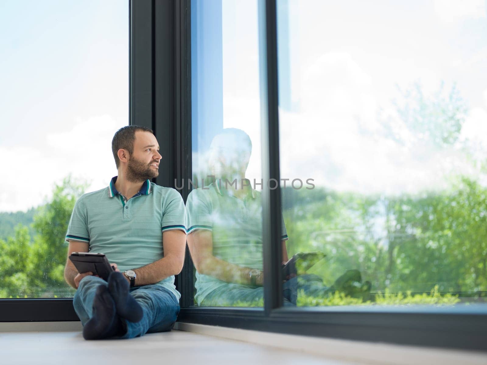 Real man Using tablet on the floor At Home Drinking Coffee Enjoying Relaxing