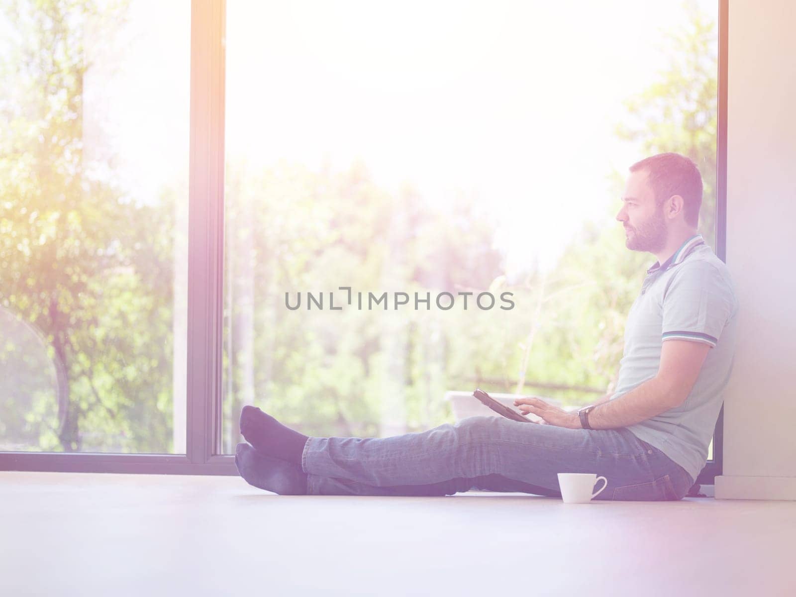 Real man Using tablet on the floor At Home Drinking Coffee Enjoying Relaxing