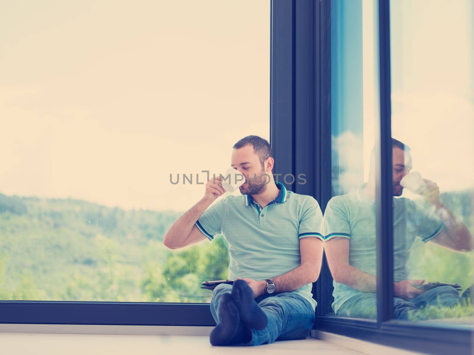 Real man Using tablet on the floor At Home Drinking Coffee Enjoying Relaxing