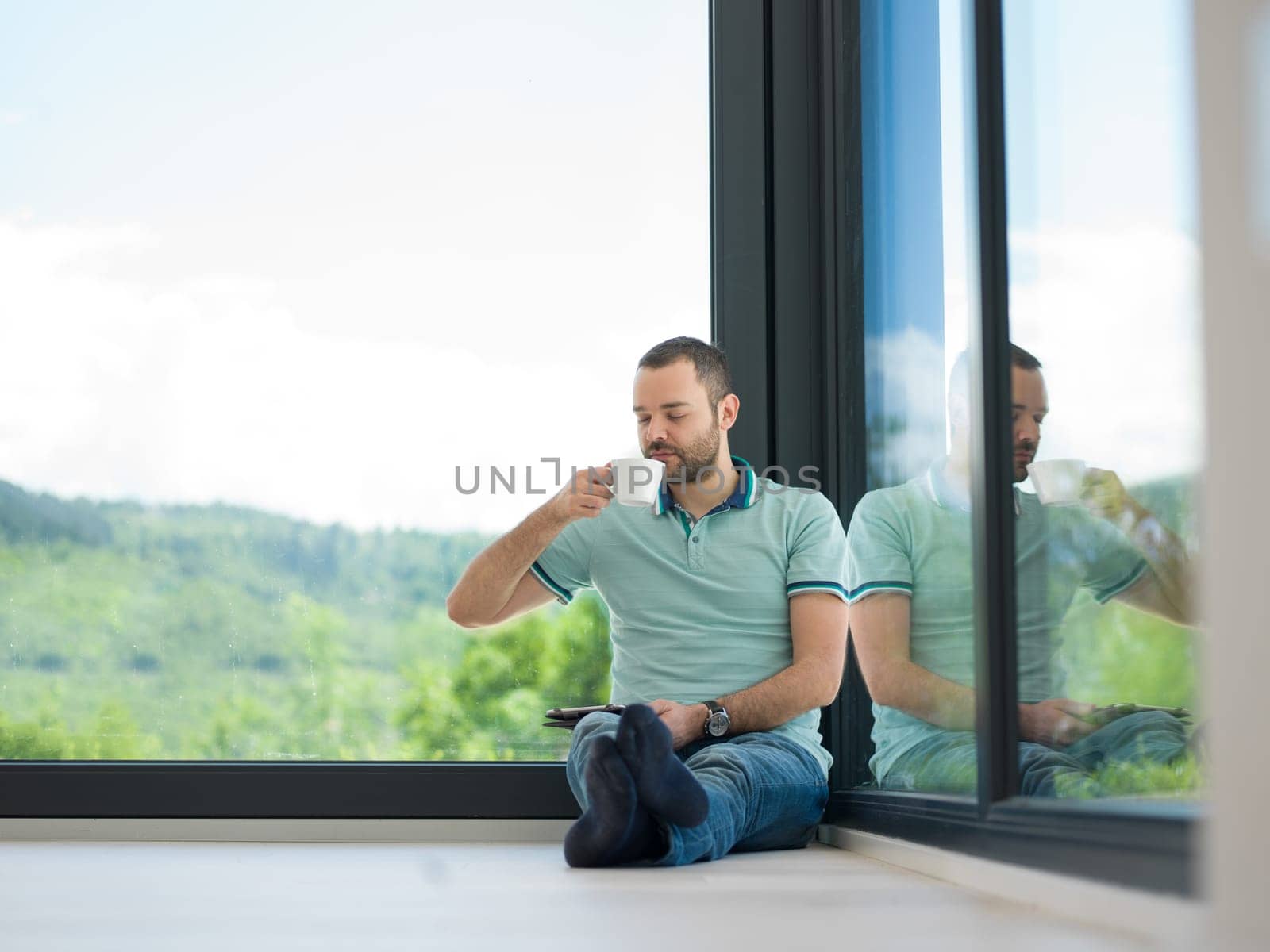 Real man Using tablet on the floor At Home Drinking Coffee Enjoying Relaxing