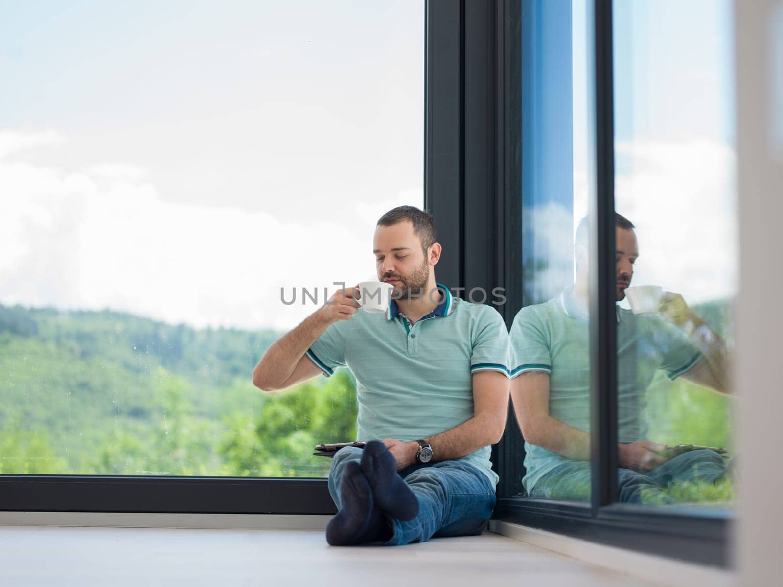 Real man Using tablet on the floor At Home Drinking Coffee Enjoying Relaxing