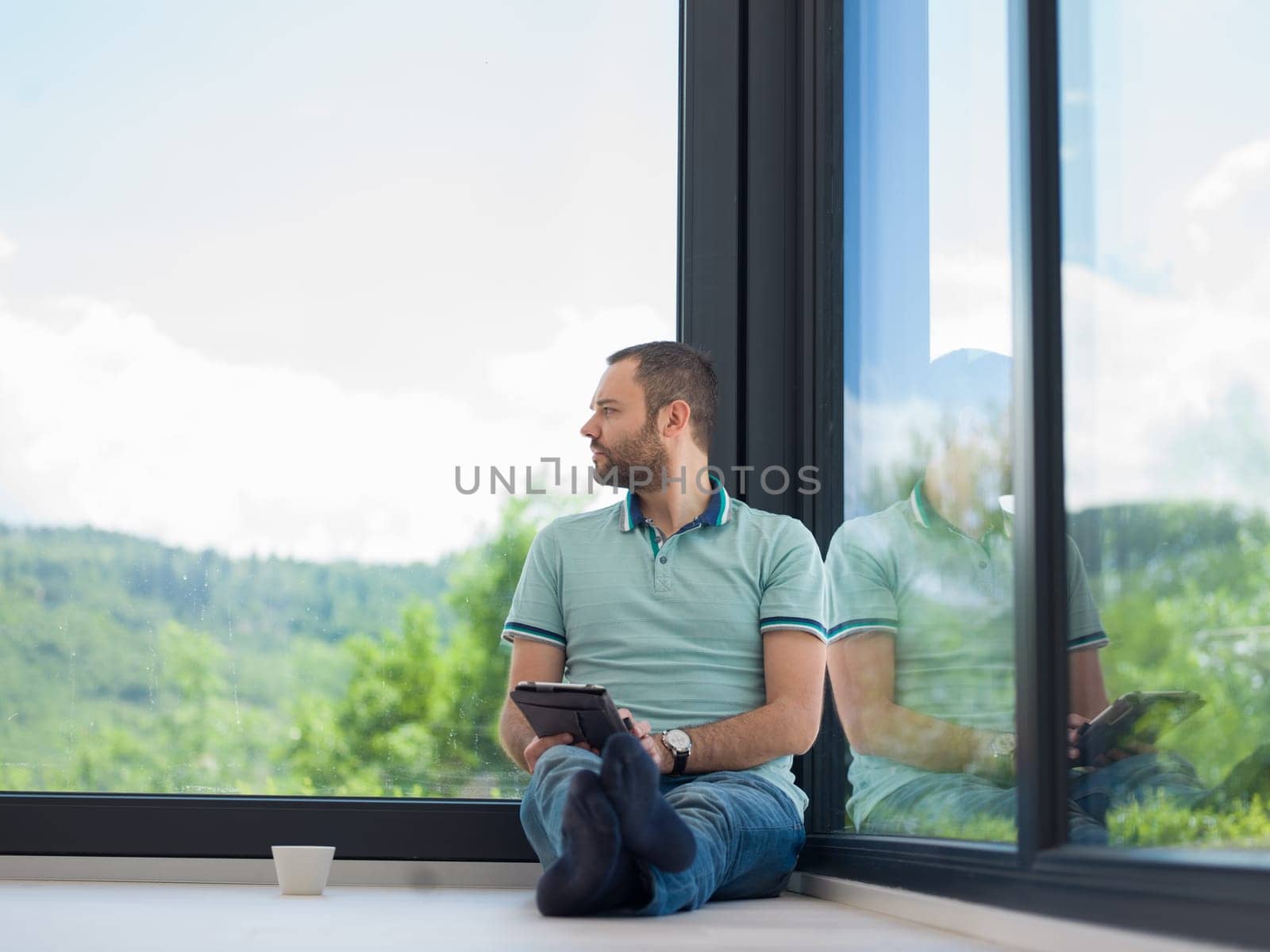 Real man Using tablet on the floor At Home Drinking Coffee Enjoying Relaxing