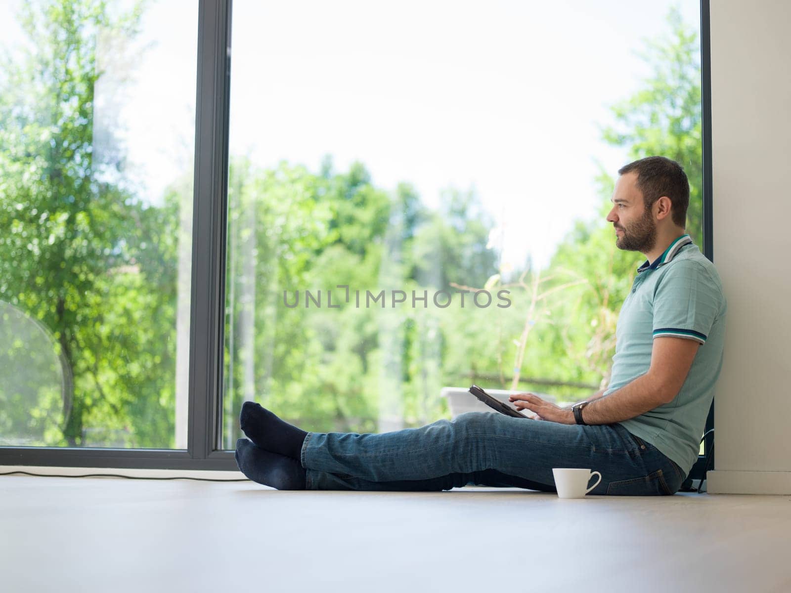 Real man Using tablet on the floor At Home Drinking Coffee Enjoying Relaxing