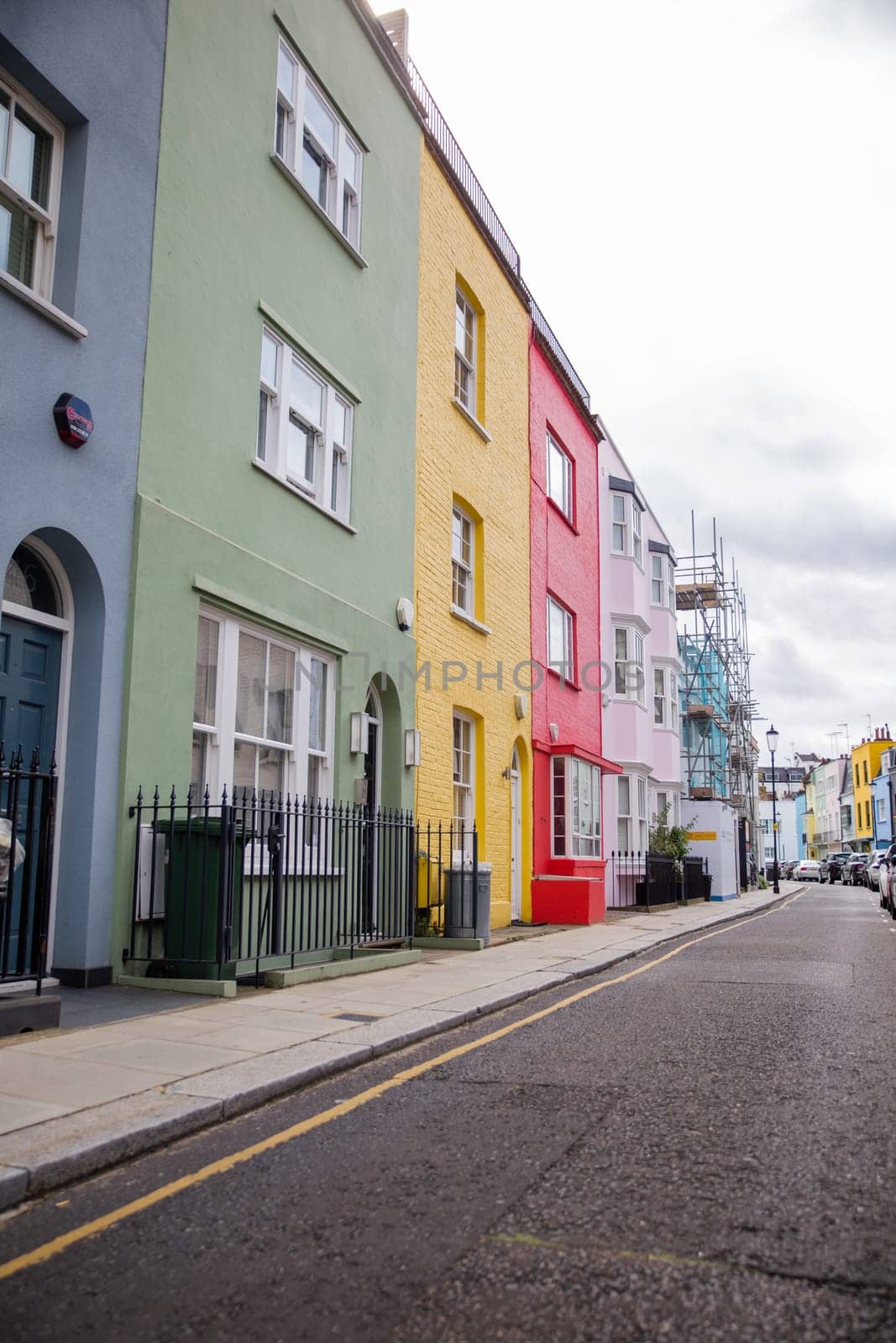 Row of small colorful British houses with handrails and plants. Beautiful pastel colors English houses with victorian architecture. Peaceful London neighborhood