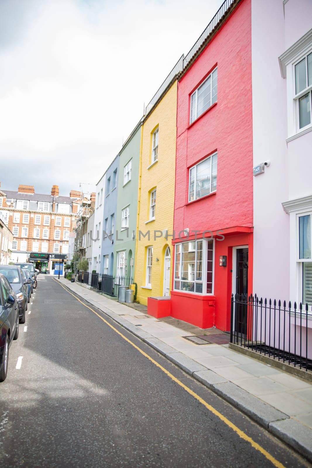 Row of small colorful British houses with handrails and plants. Beautiful pastel colors English houses with victorian architecture. Peaceful London neighborhood