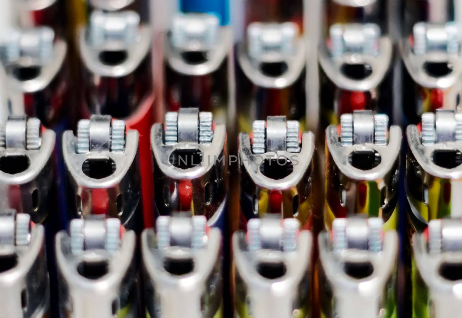Close-up view of a group of many plastic lighters arranged in rows. Selective focus. Smoking and accessories. Concept of teamwork and unity