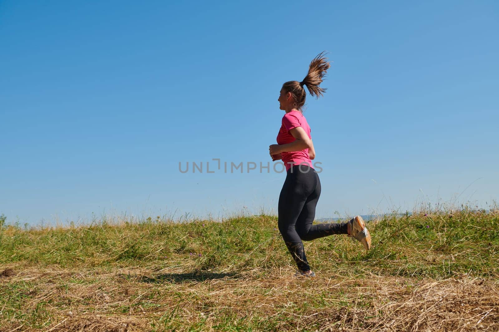 woman  jogging in a healthy lifestyle on a fresh mountain air at beautiful sunny summer nature