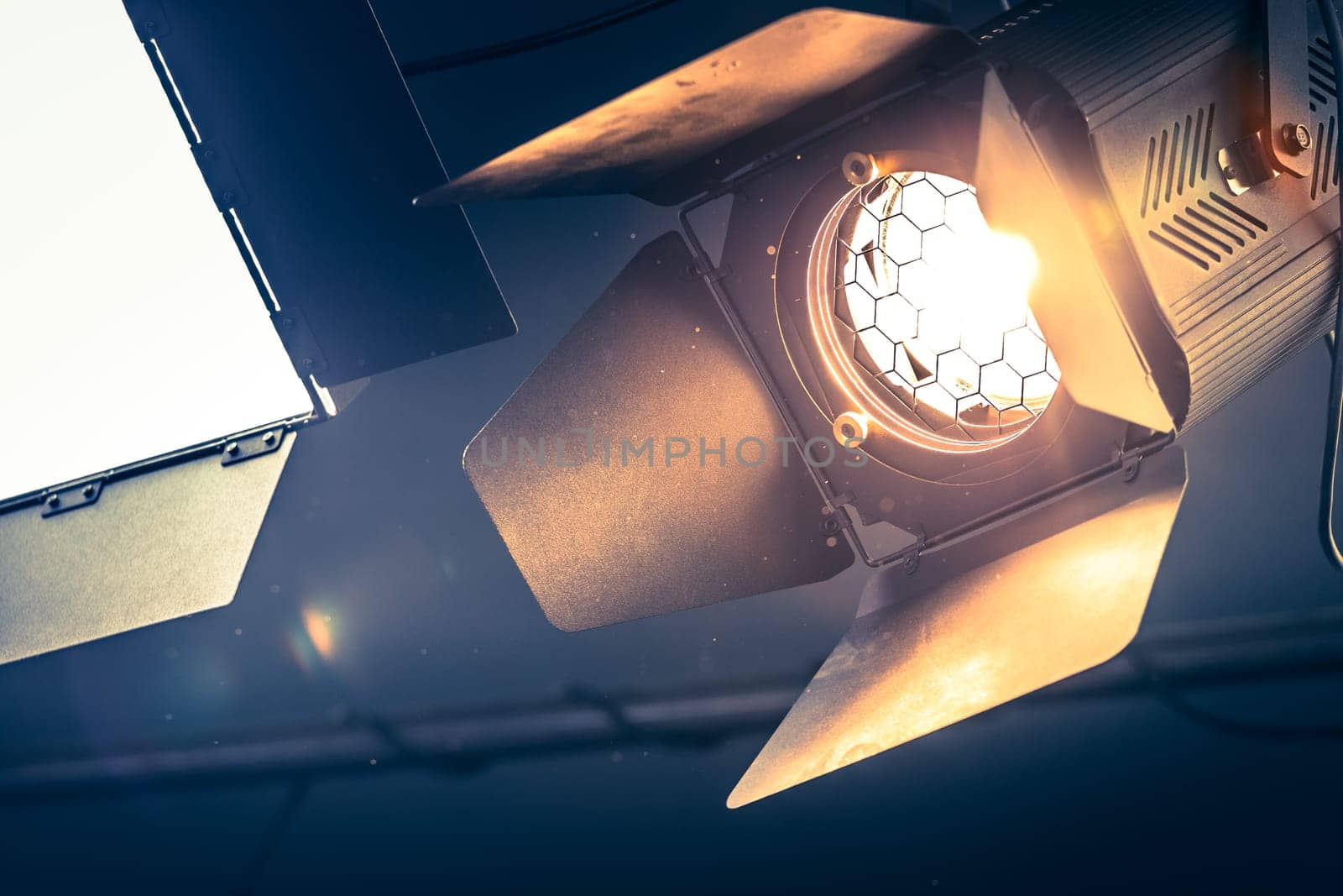 Professional orange studio spotlight hanging on the ceiling.