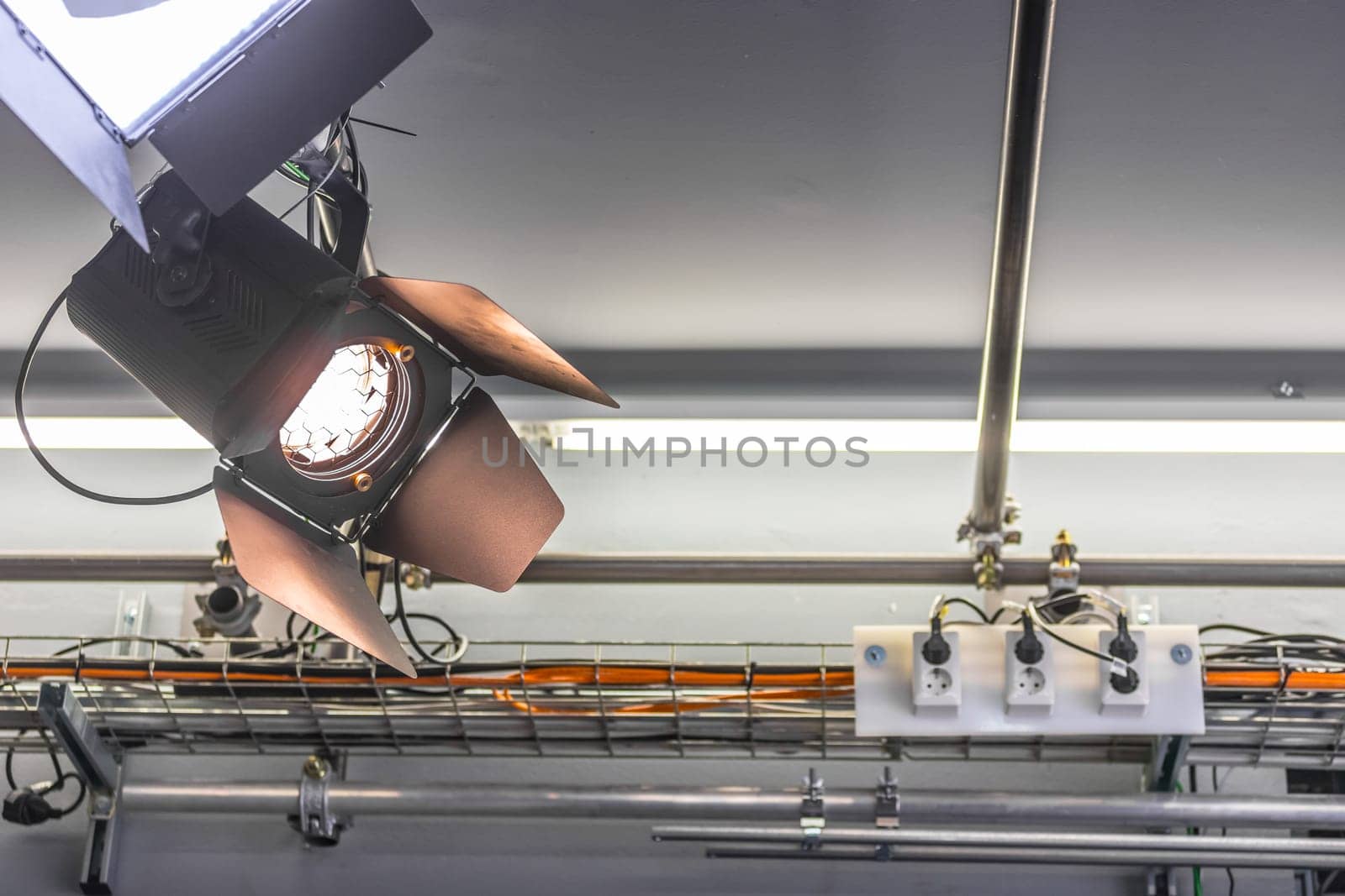 Professional orange studio spotlight hanging on the ceiling.