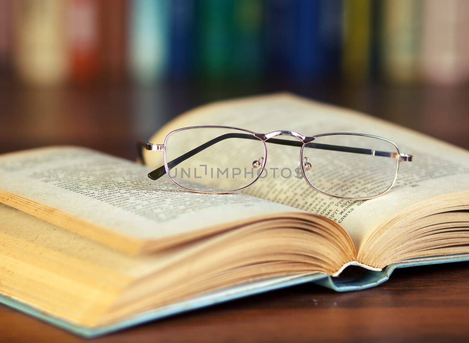 glasses and book on background bookcase
