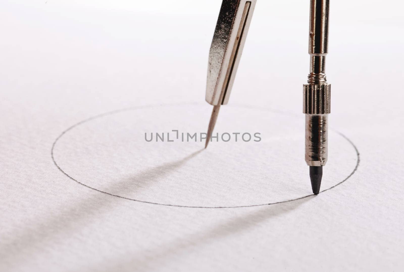 pair of compasses drawing circle on a paper