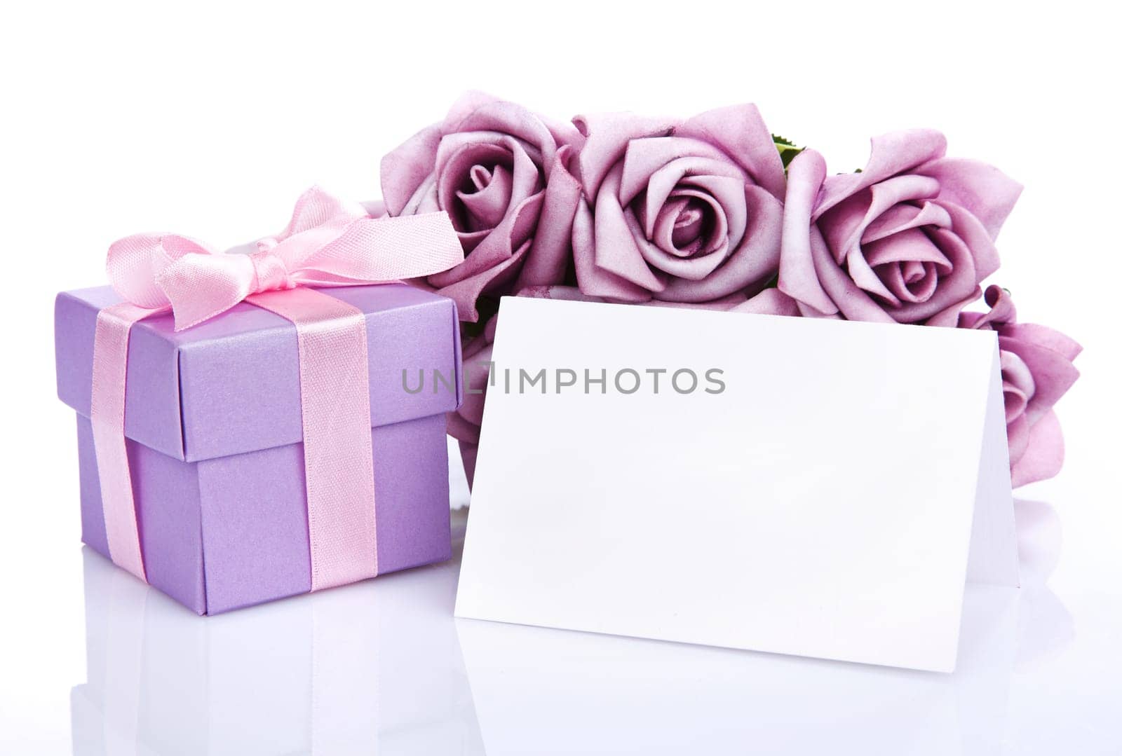 Greeting card with purple flowers and gift box with ribbon and bow on a white background