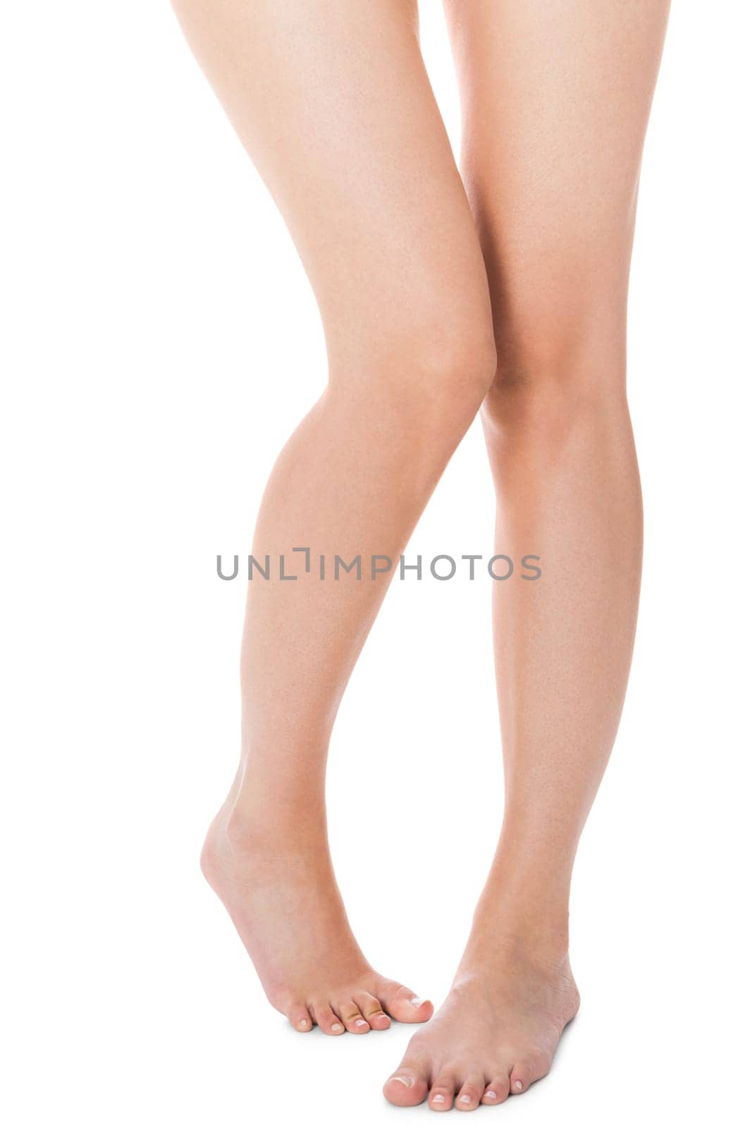 Elegant long shapely naked female legs with bare feet insulated on white with text space