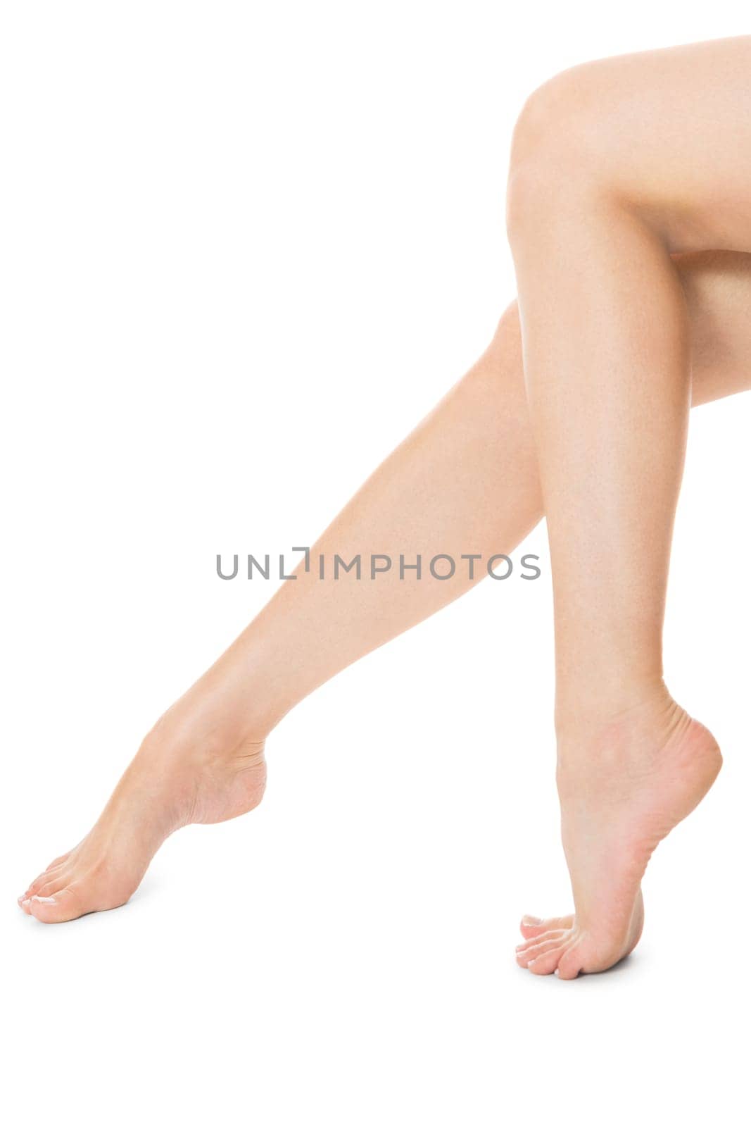 Elegant long shapely naked female legs with bare feet insulated on white with text space