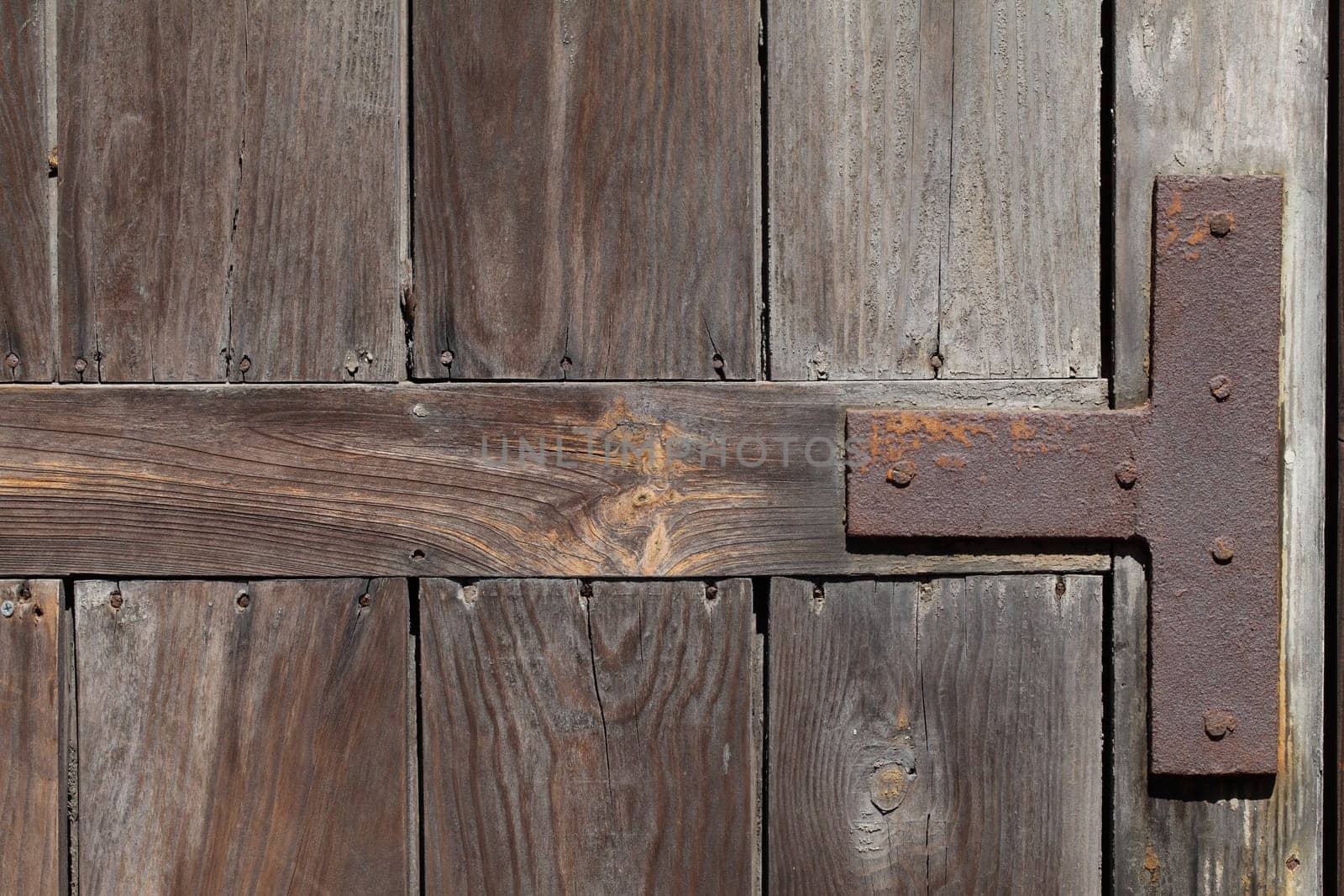 Old weathered wooden door reinforced with iron