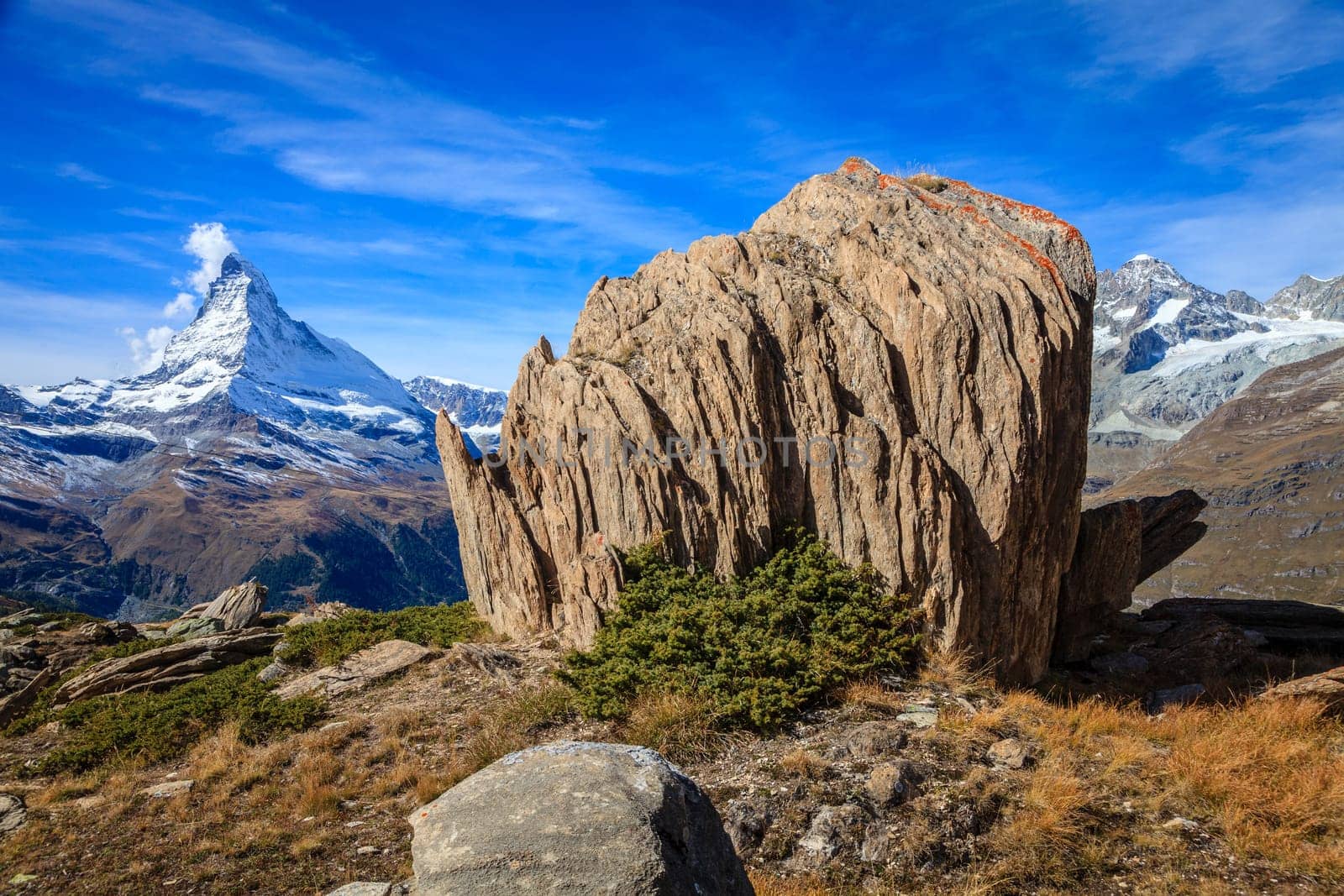 Layered rock outcropping in Swiss Alps with Matterhorn in the backdrop