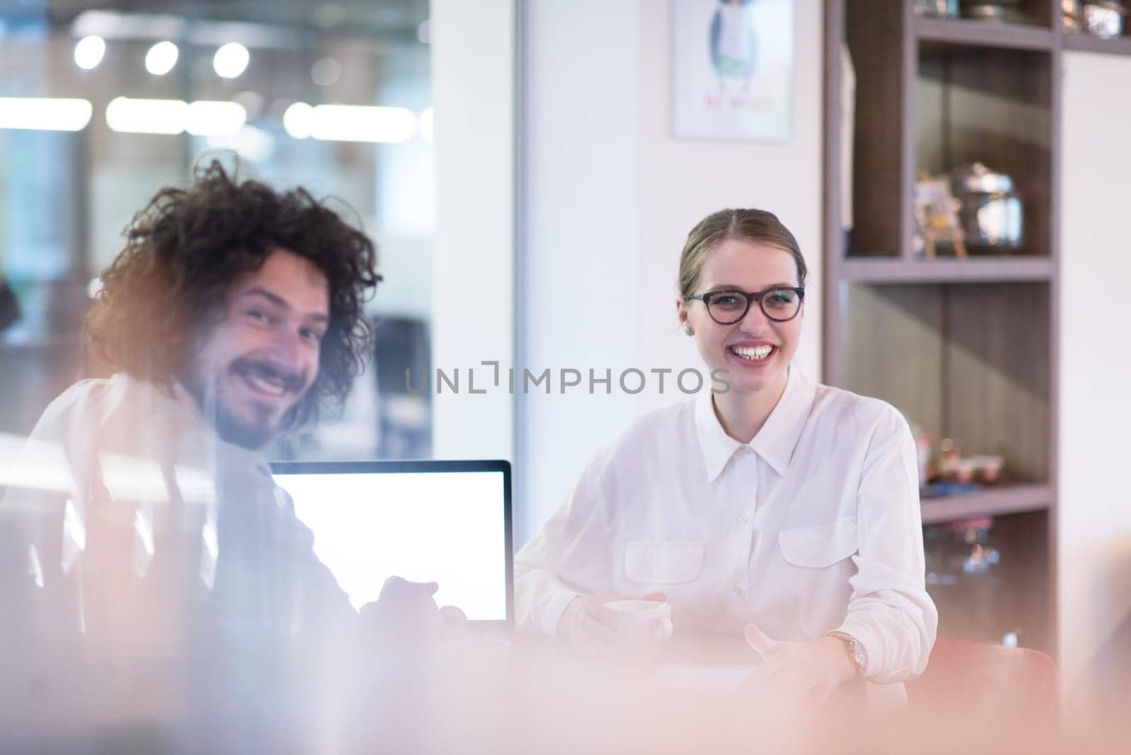 startup business people using laptop preparing for next meeting while drinking coffee and discussing ideas in creative office
