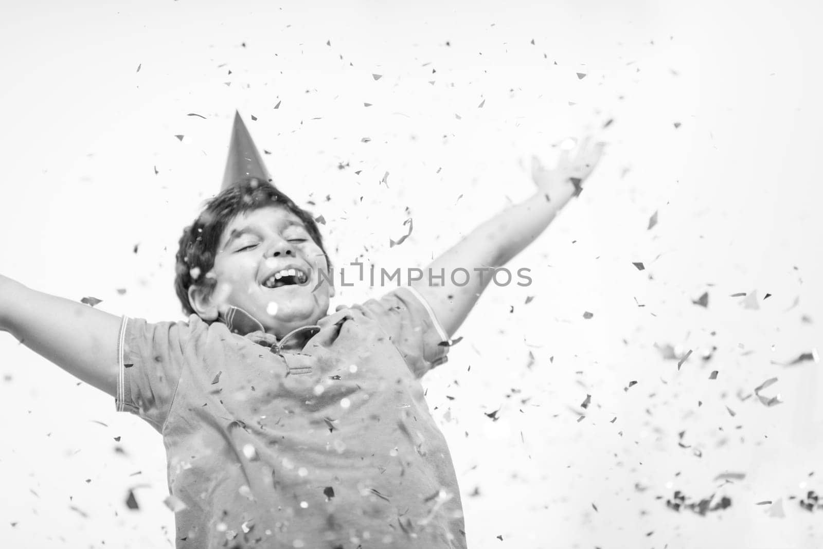 Happy kid celebrating party with blowing confetti