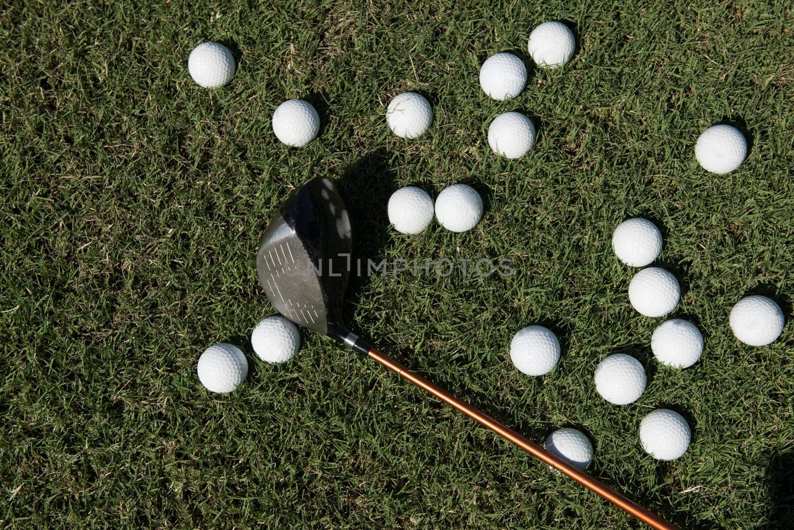 top view flat lay of golf balls with driver on grass background