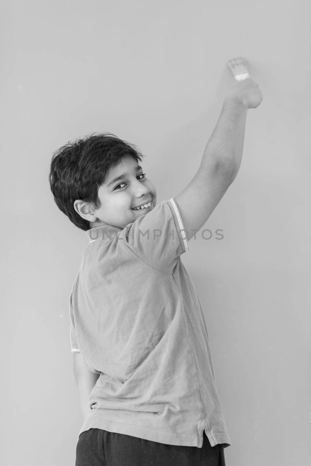 Portrait of a young boy painter with a brush in his hand in front of colored background