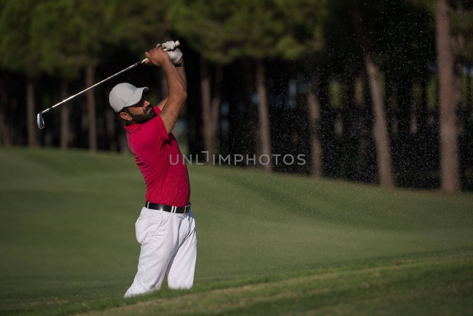 golf player shot ball from sand bunker at course