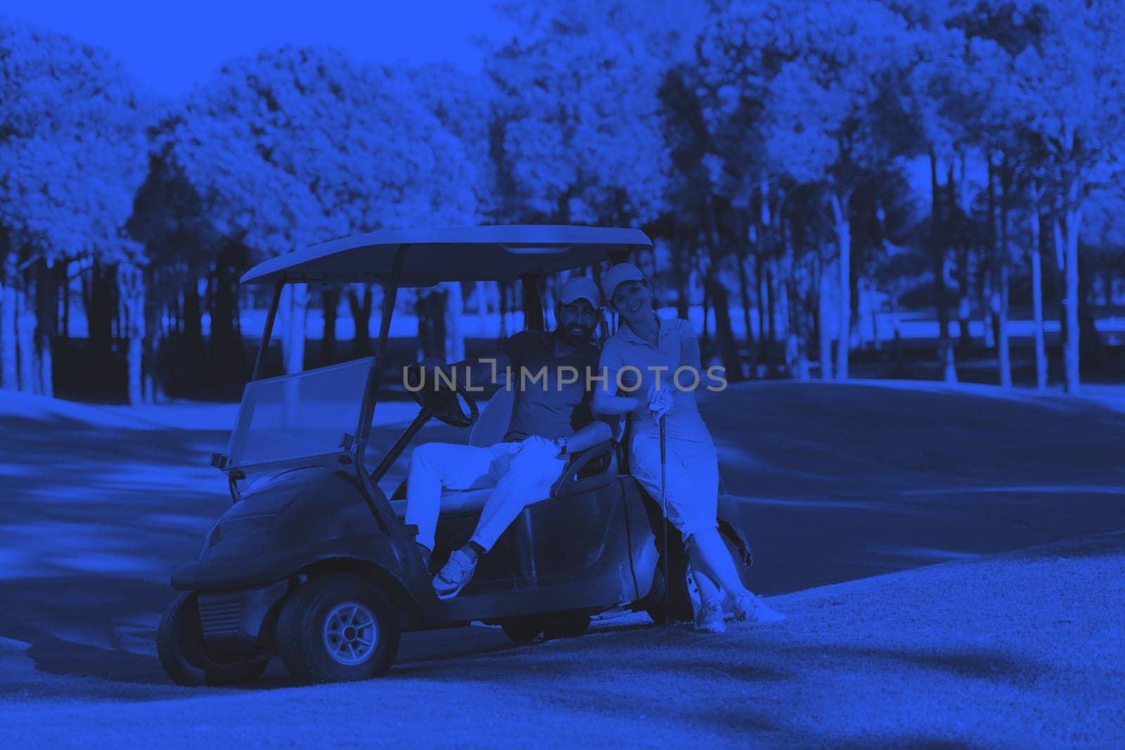 couple in buggy cart on golf course duo tone
