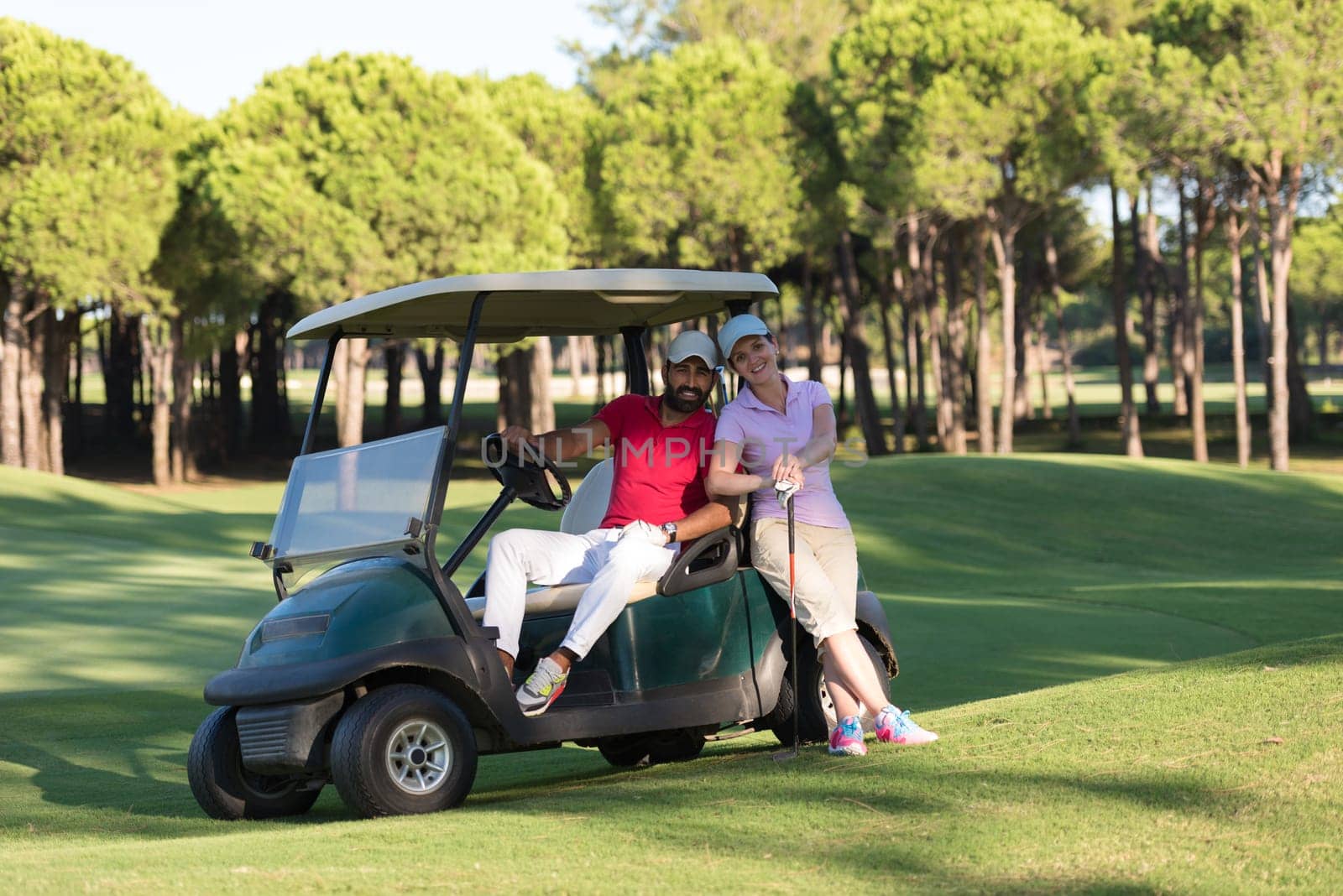 couple in buggy cart on golf course
