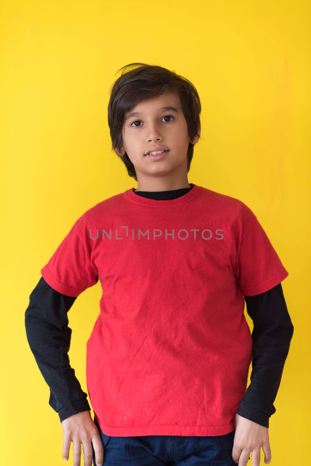Portrait of a happy young boy in front of colored background