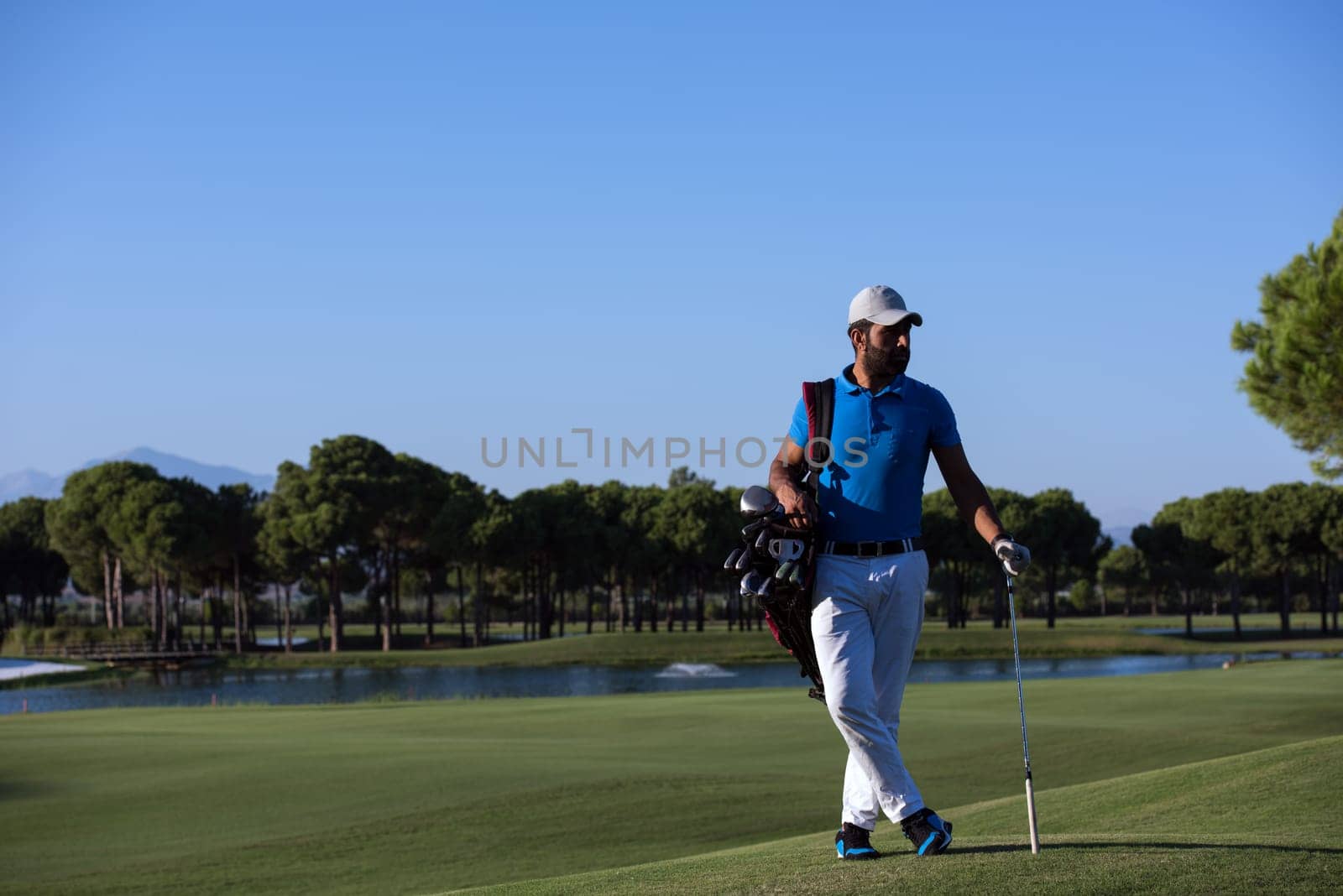 handsome middle eastern golf player portrait at course at sunny day