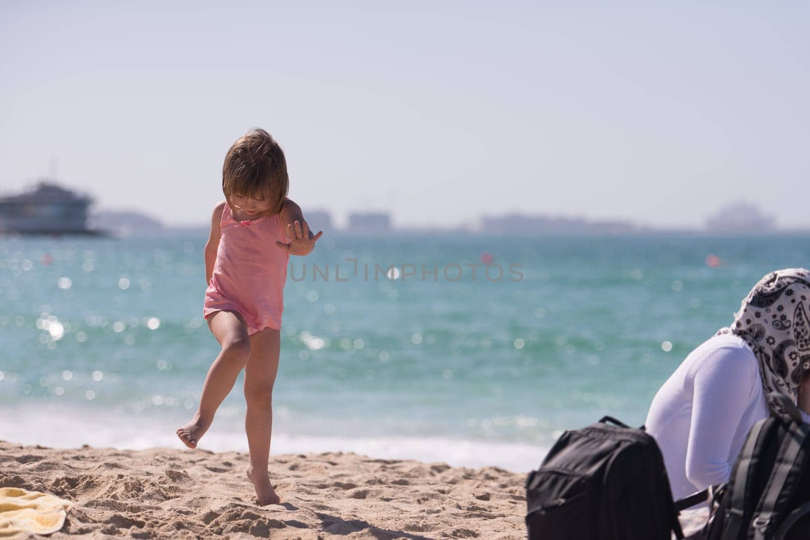 happy little girl at the seaside in the summer.Adorable little girl at beach during summer vacation. Happy baby by the sea or ocean