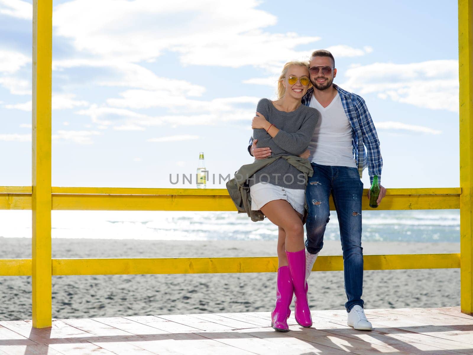 Couple Drinking Beer Together in empty beach bar during autumn time