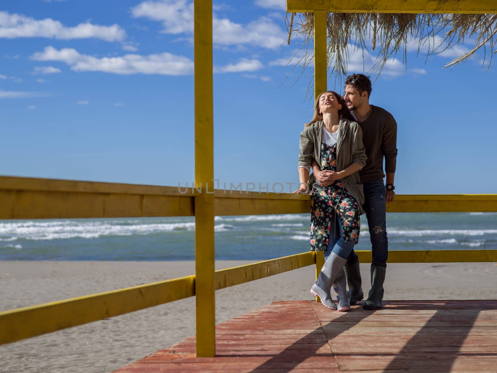 Happy couple enyojing time together on beach during autumn day