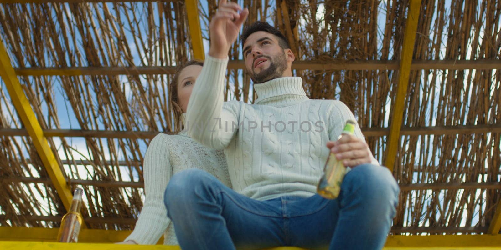 Couple Drinking Beer Together on beach during autumn time