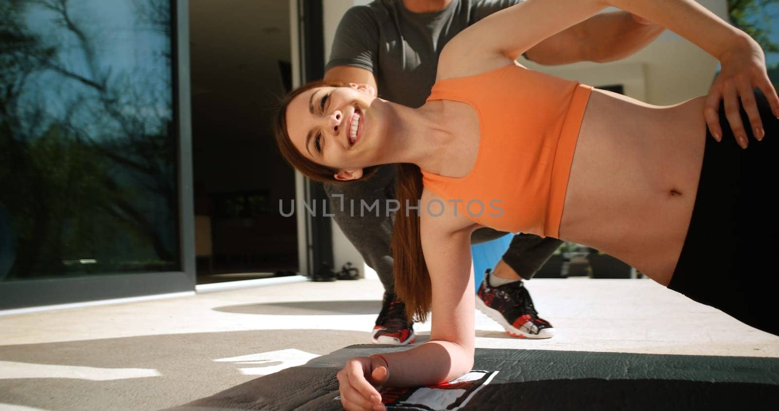sporty couple exercising together  on terace in front of mansion