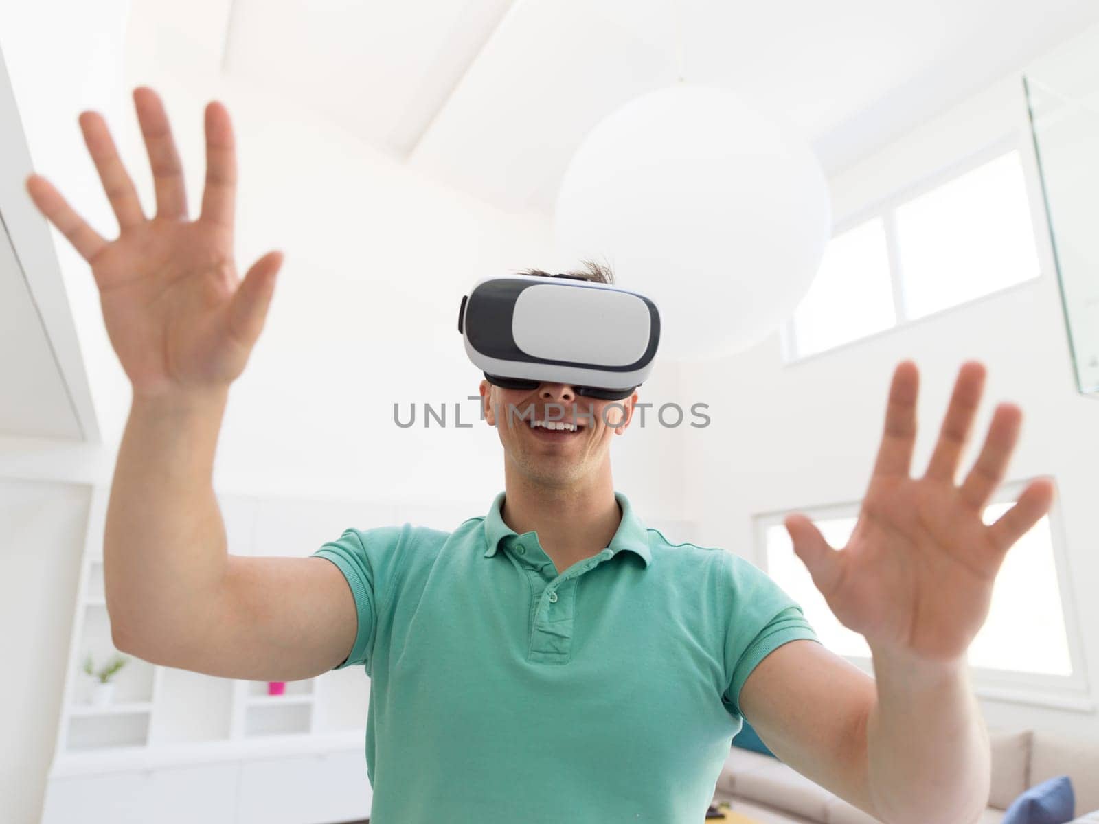 happy man getting experience using VR-headset glasses of virtual reality at home