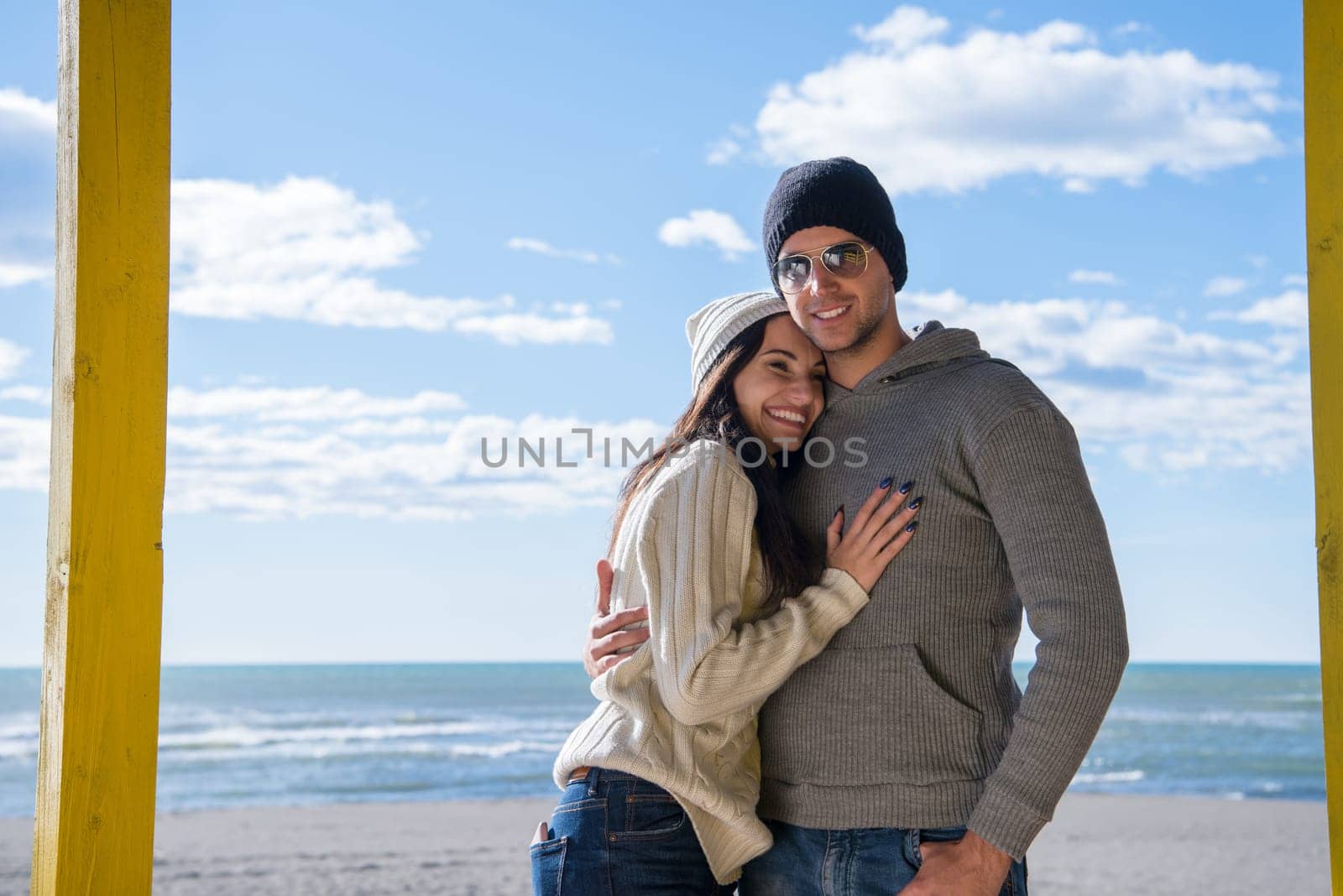 Happy couple enyojing time together on beach during autumn day