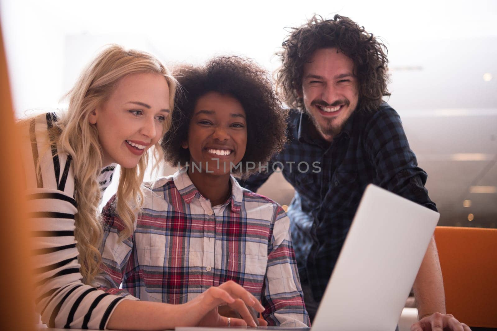 Multiethnic startup business team on meeting in modern bright office interior brainstorming, working on laptop and tablet computer