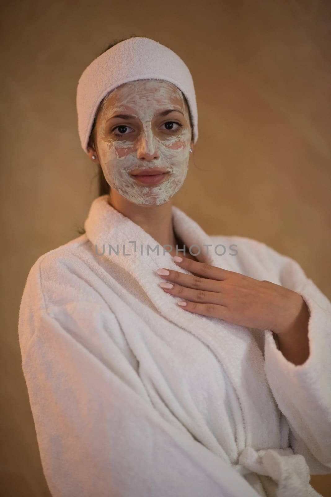 Spa Woman applying Facial Mask  Beauty Treatments  Close up portrait of beautiful girl with a towel on her head applying facial mask
