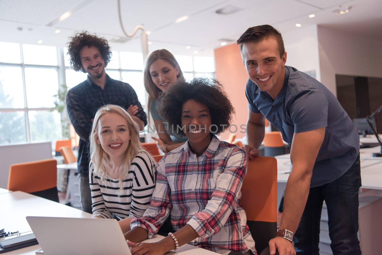 Multiethnic startup business team on meeting in modern bright office interior brainstorming, working on laptop
