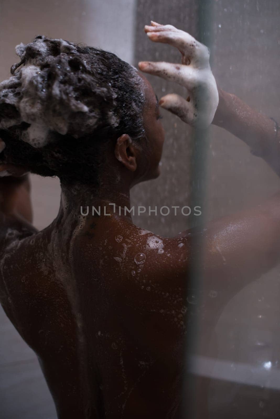 Woman in the shower,beautiful black young female showering under refreshing water, healthy lifestyle, enjoying time in luxury spa resort