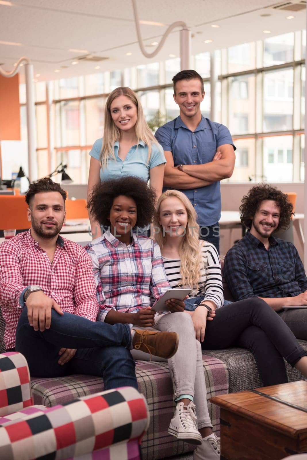 Multiethnic startup business team on meeting in modern bright office interior brainstorming, working on laptop and tablet computer