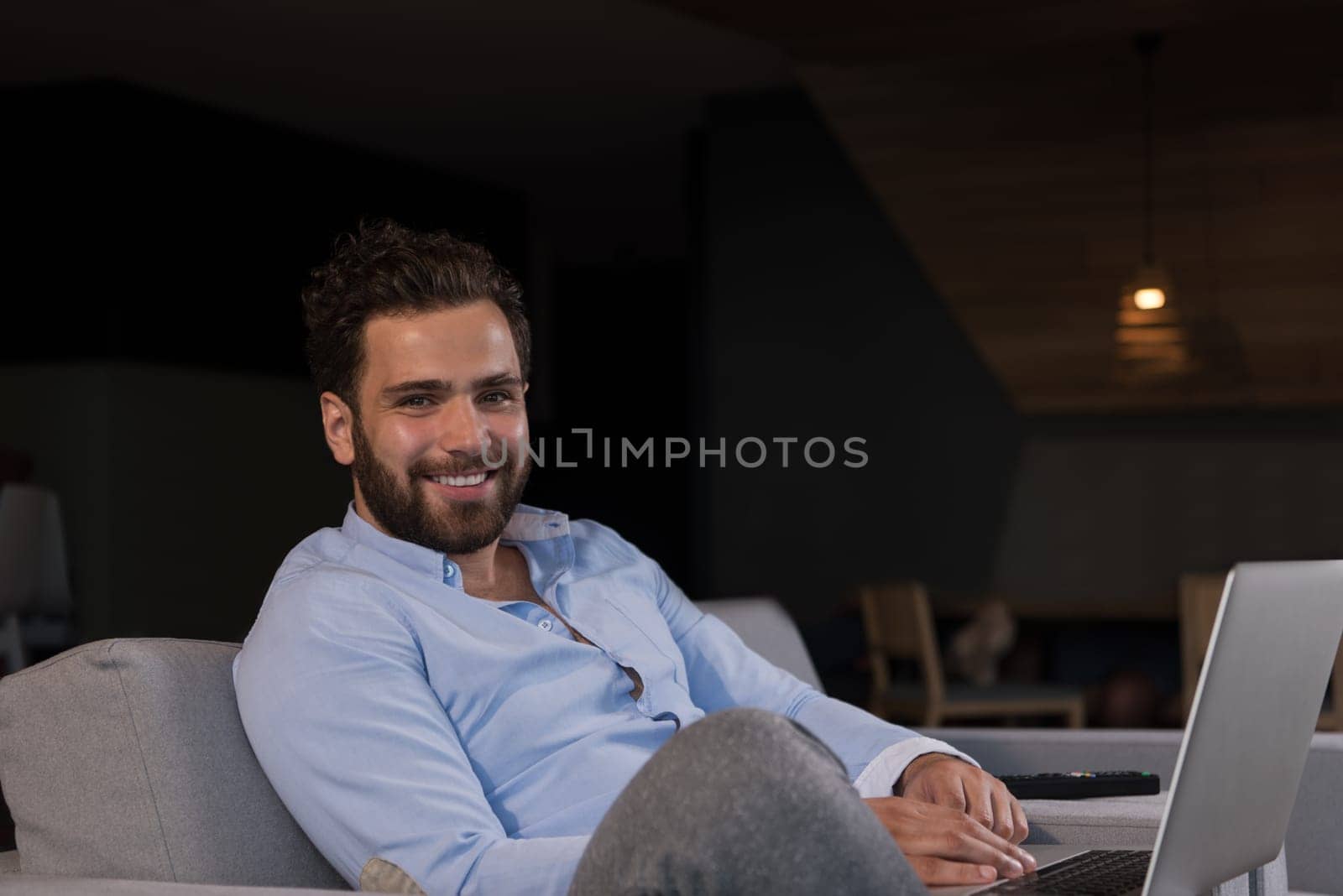 technology, home and lifestyle concept  of man working from home using laptop computer and sitting on sofa