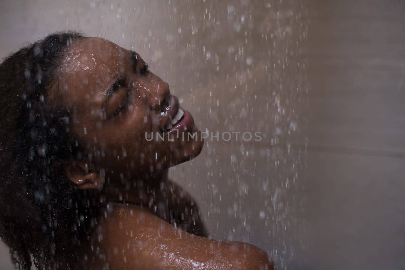 Woman in the shower,beautiful black young female showering under refreshing water, healthy lifestyle, enjoying time in luxury spa resort