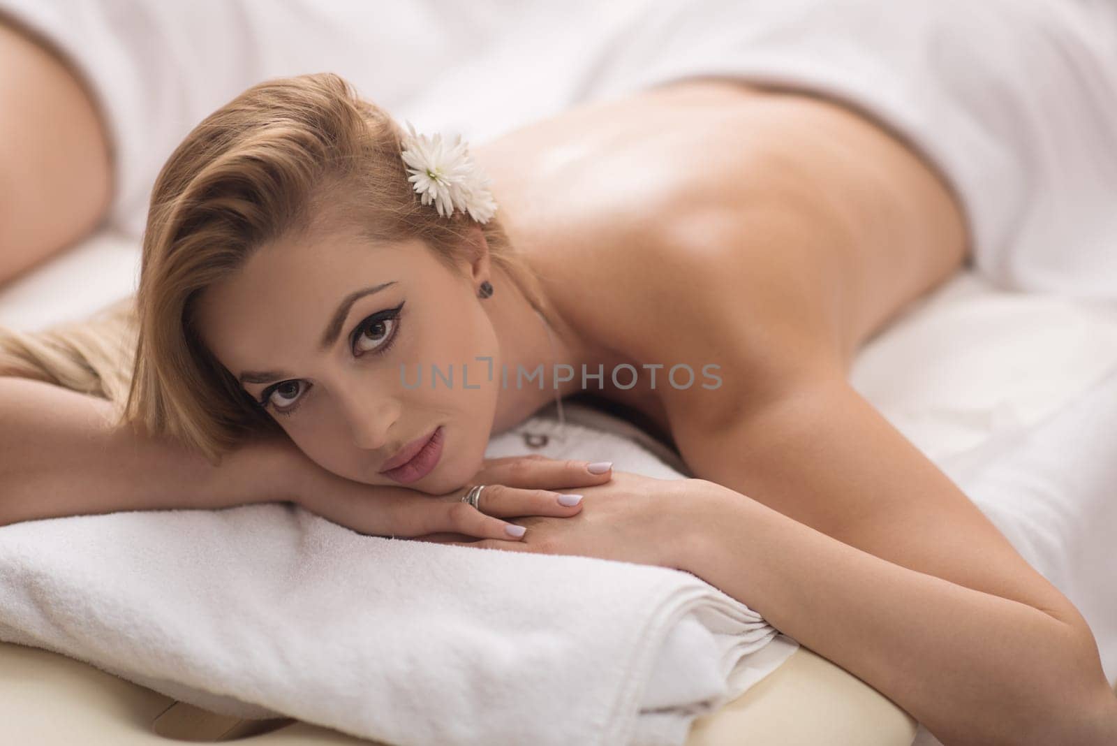Relaxed young beautiful  woman laying on massage table
