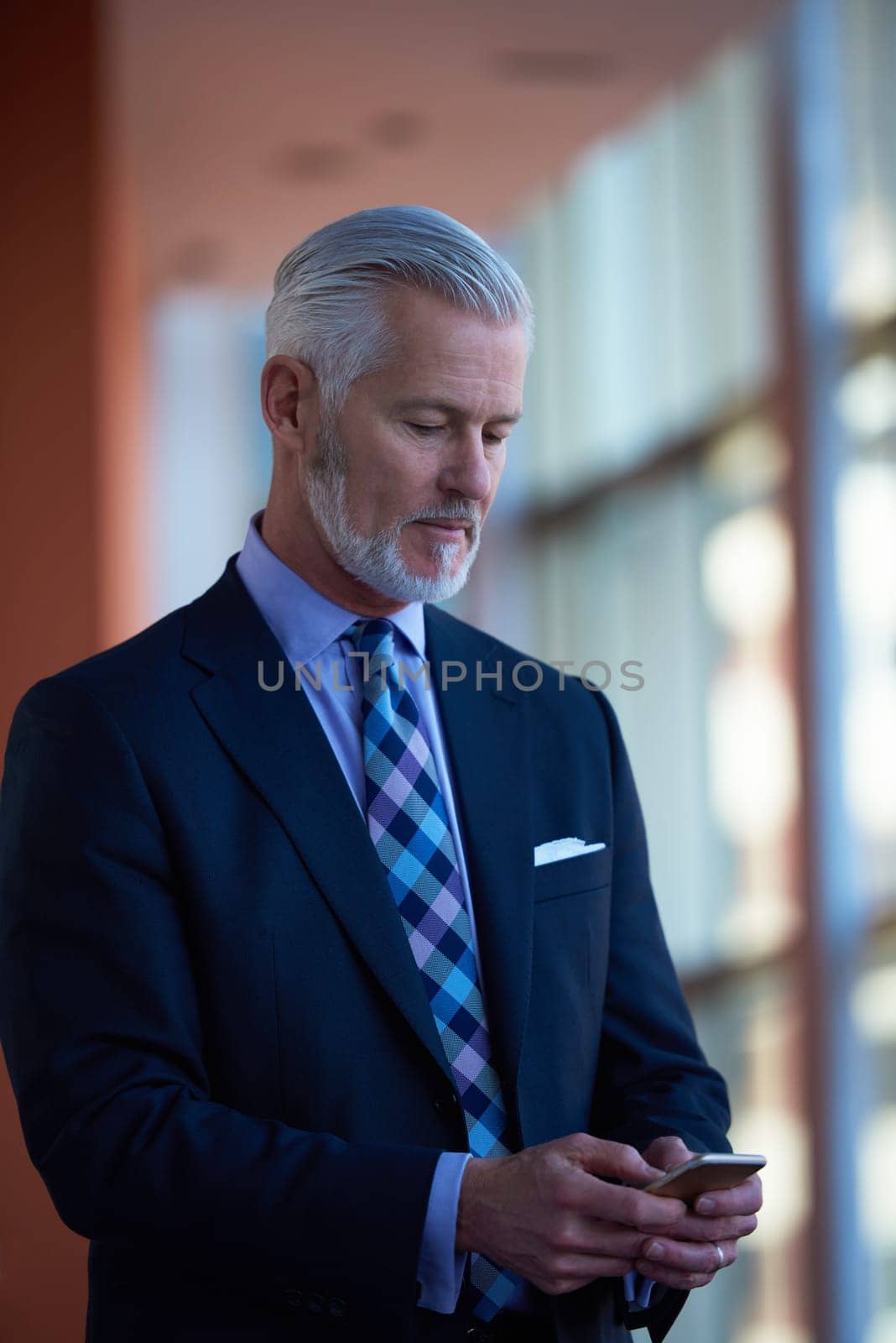 senior business man talk on mobile phone  at modern bright office interior
